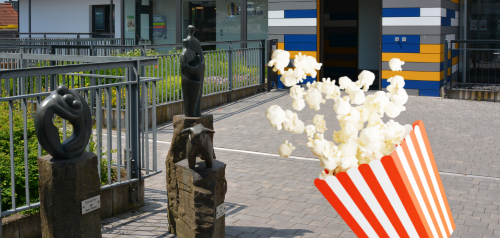 Popcorn-Tüte Vordergrund vor Stadtbibliothek