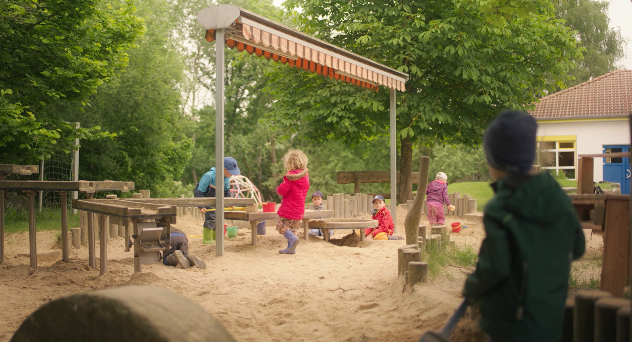 Kinder spielen im Außenbereich der Kita Buchfinkenland in Michelsrombach im Sandkasten