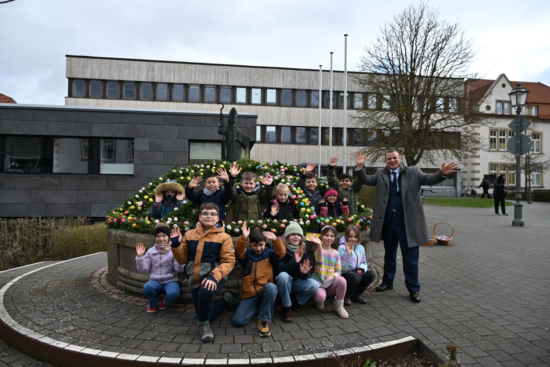 Bürgermeister mit Kindern am geschmückten Brunnen