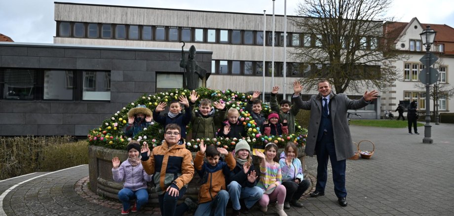 Bürgermeister mit Kindern am geschmückten Brunnen